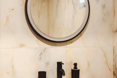 a bathroom with a round mirror on the wall at Villa Vriko in Agia Marina Nea Kydonias