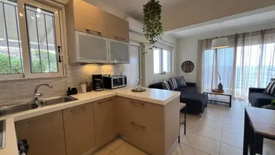 a kitchen with a sink and a living room at What a View Villa - Amazing Sea & Sunset Panorama with Pool in Chania Town