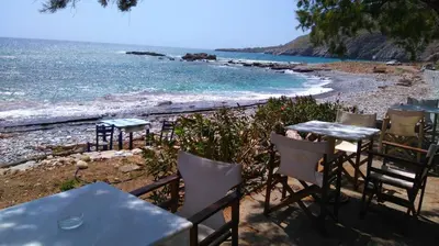 a group of tables and chairs on a beach at Georgoshouse Lykos beach Sfakia in Livanianá