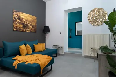 a living room with a blue couch and yellow pillows at Peggy's house by 8essentially in Chania Town