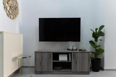 a flat screen tv sitting on top of a wooden entertainment center at Peggy's house by 8essentially in Chania Town