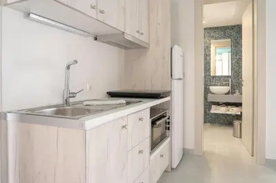 a white kitchen with a sink and a refrigerator at Paradisos in Frangokastello