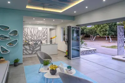 a living room with a glass door leading to a garden at Paradisos in Frangokastello