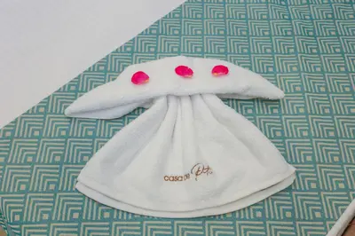 a white towel with red eyes on top of a table at Casa De Potie in Chania Town