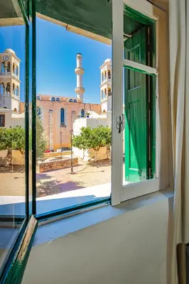 an open window with a view of a mosque at Ydragogeio Rooms Old Town in Chania Town