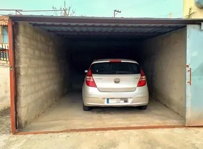 a white car is parked in a garage at Village house with a nice garden in Stérnai