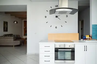 a kitchen with a clock on the wall at The Teacher's Home 2 minutes away from the beach in Galatás