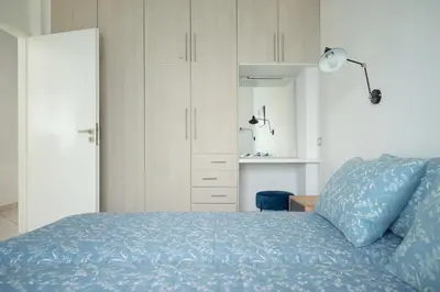 a bedroom with a blue bed and a white cabinet at The Teacher's Home 2 minutes away from the beach in Galatás