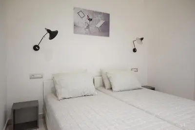 a bedroom with a bed with two lamps on the wall at The Teacher's Home 2 minutes away from the beach in Galatás
