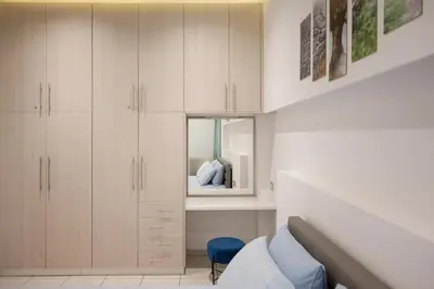 a bedroom with white cabinets and a blue chair at The Teacher's Home 2 minutes away from the beach in Galatás