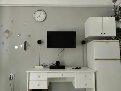 a white desk with a television on a wall with a refrigerator at central cozy and lovely house in Chania Town