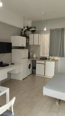 a kitchen with white cabinets and a sink and a table at central cozy and lovely house in Chania Town