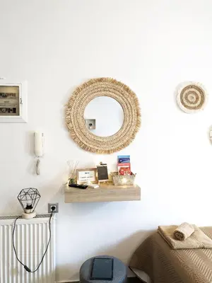a mirror on a wall with a shelf and a bed at Cozy Apartment in Chania Town
