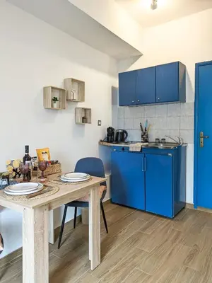 a kitchen with blue cabinets and a wooden table at Cozy Apartment in Chania Town