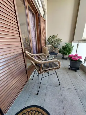 a balcony with chairs and a table and flowers at Rika's Sea View Apartment in Chania Town
