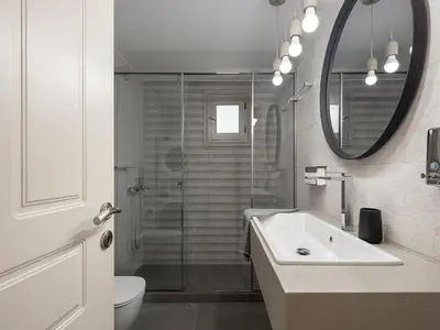a bathroom with a shower and a sink and a mirror at La Torre Villa in Palio Gerani