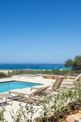 a swimming pool with chaise lounge chairs and a swimming pool at Falasarna's Dream in Kissamos