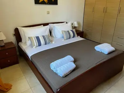 a bedroom with a large bed with two towels on it at Seaside cozy apartment in Aghii Apostoli