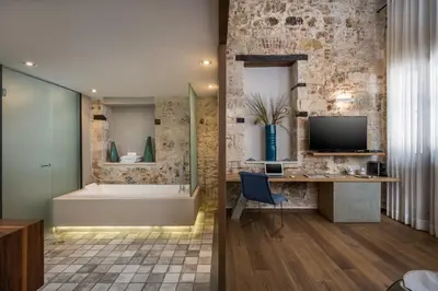 a bathroom with a tub and a desk and a television at Ambassadors Residence Boutique Hotel in Chania Town