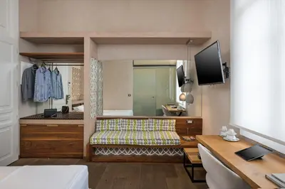 a bedroom with a bed and a desk and a tv at Ambassadors Residence Boutique Hotel in Chania Town