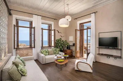 a living room with a couch and a tv at Ambassadors Residence Boutique Hotel in Chania Town