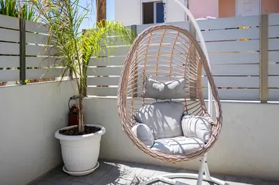 a hanging rattan chair sitting on a balcony at Fanouris Luxury Apartments 2 in Chania Town