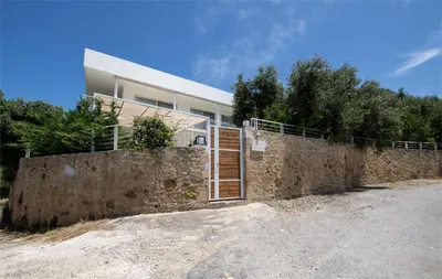 a house with a stone wall and a fence at Freya's Royal Estate, Kissamos in Khairethianá