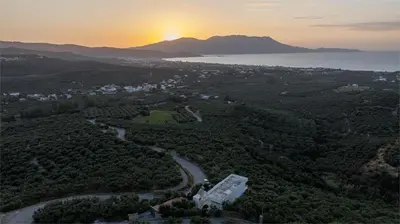an aerial view of a city with the sunset in the background at Freya's Royal Estate, Kissamos in Khairethianá