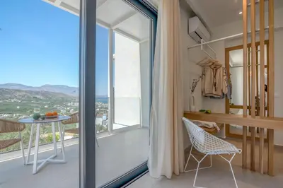 a room with a large window and a table and chair at Onar Villa - staying in comfort in Kissamos