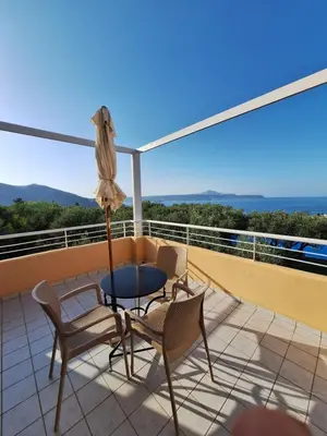 a patio with a table and chairs on a balcony at Artemis Apartments in Kalyves