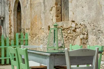 a green table with chairs and a lantern on it at NiMa Maison in Kissamos