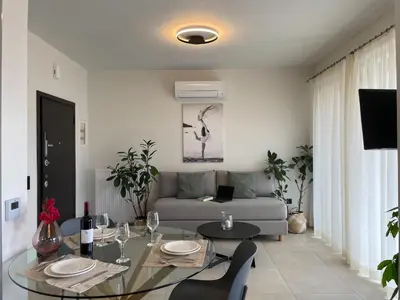 a living room with a table and a couch at Mossa City Apartments - 2 km from Old Town - Private parking in Chania Town