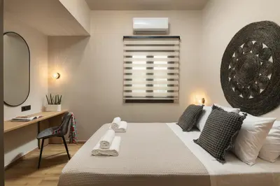 a bedroom with a bed with a desk and a window at Limani elegant apartments in Souda