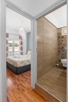 a bedroom with a bed and a bathroom at 3 bedroom apt in Nea Chora 400 meters walk to the beach in Chania Town