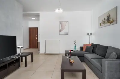 a living room with a couch and a tv at 3 bedroom apt in Nea Chora 400 meters walk to the beach in Chania Town