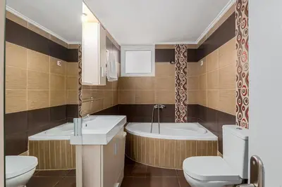 a bathroom with two sinks and a tub and a toilet at 3 bedroom apt in Nea Chora 400 meters walk to the beach in Chania Town