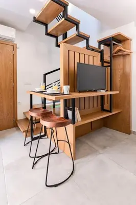 a room with a desk with a tv and stools at Casa Nicola's in Chania Town