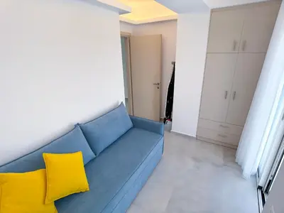 a blue couch with yellow pillows in a living room at Luxury Dream with Private Jacuzzi in Kaloudhianá