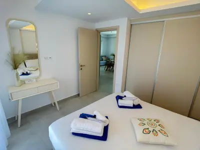 a bedroom with a bed and a mirror and towels at Luxury Dream with Private Jacuzzi in Kaloudhianá