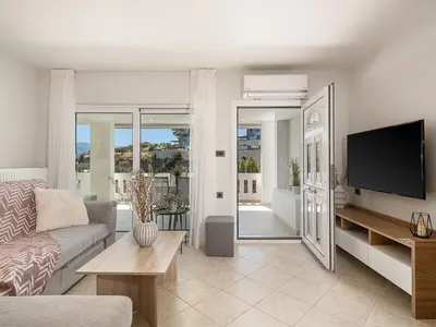 a living room with a couch and a tv at Elysian Sea-View Chania in Stérnai