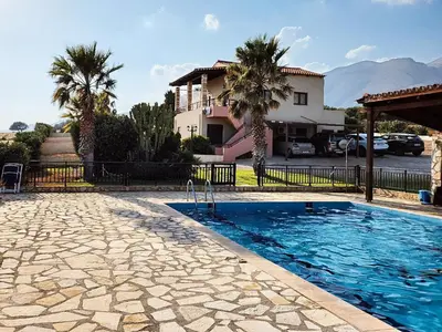 a swimming pool in front of a house with palm trees at Dreamy South Sea View Apartments with Pool in Frangokastello