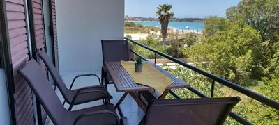 a table and chairs on a balcony with a view of the ocean at Sun Beach Apartments in Chania 8 &10& 13 in Chania Town
