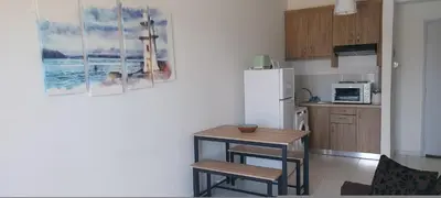 a kitchen with a small table and a refrigerator at Sun Beach Apartments in Chania 8 &10& 13 in Chania Town