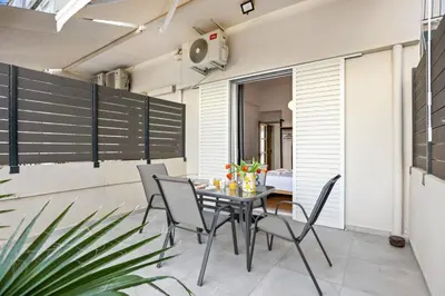 a dining room with a table and chairs on a patio at Apartment Arancione in Chania Town