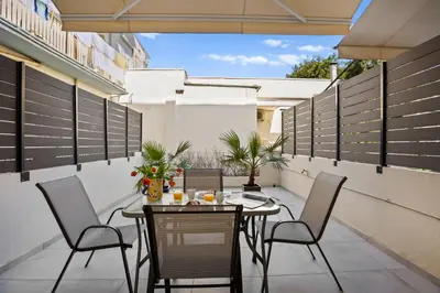 a patio with a table and chairs on a balcony at Apartment Arancione in Chania Town