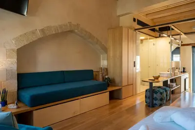 a living room with a blue couch in a room at Kallergon Luxury Suites in Chania Town