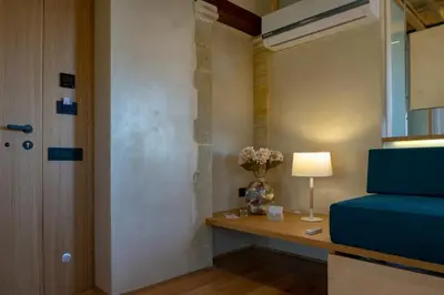 a room with a blue couch and a table with a lamp at Kallergon Luxury Suites in Chania Town