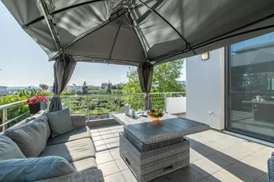 a patio with a couch and a table on a balcony at Crystal Waves lux villa-Homeleader in Chania Town