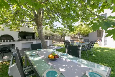 a table with a bowl of fruit on it in a yard at Crystal Waves lux villa-Homeleader in Chania Town