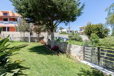 a yard with a fence and a tree at Crystal Waves lux villa-Homeleader in Chania Town